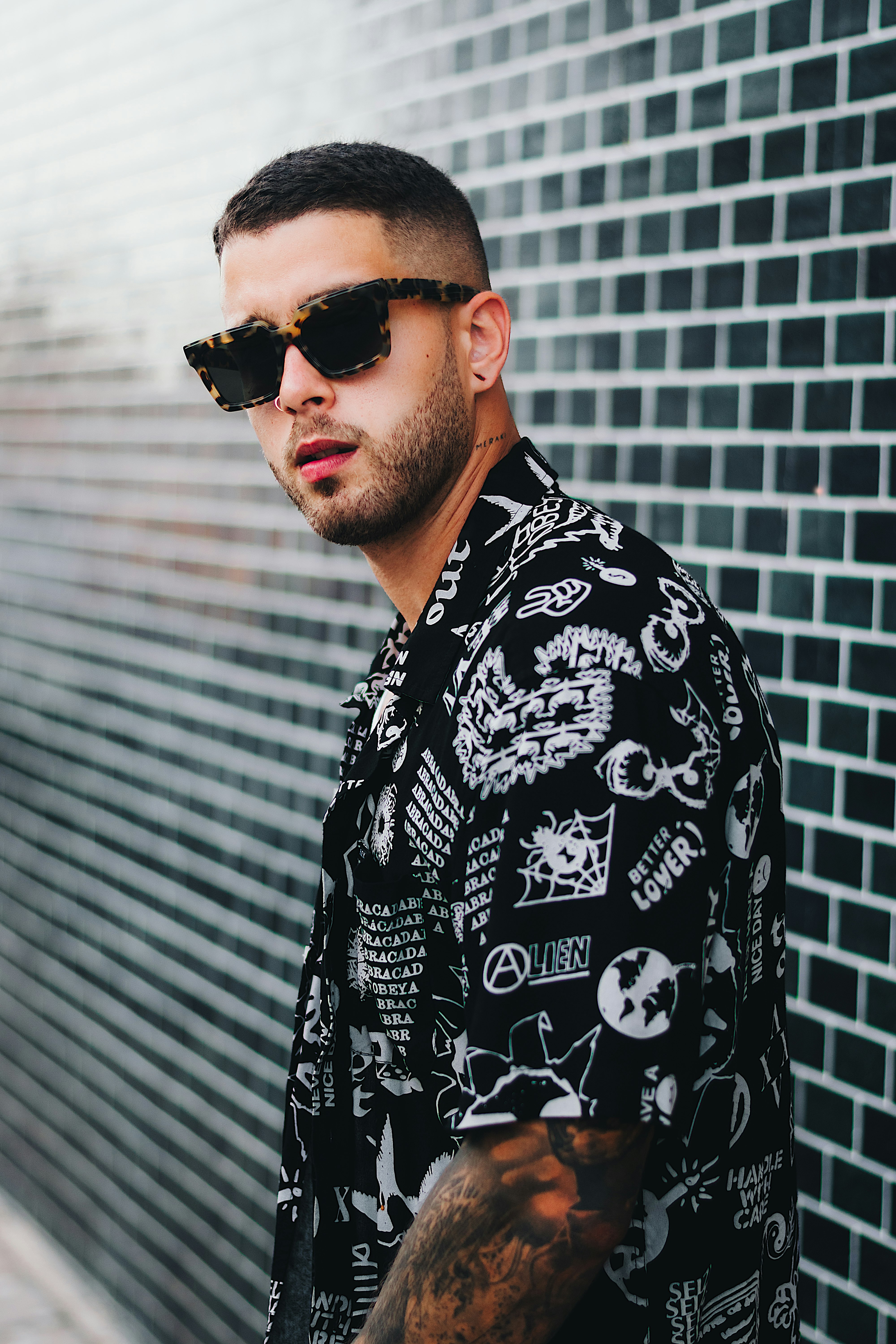 man in black and white floral button up shirt wearing black sunglasses